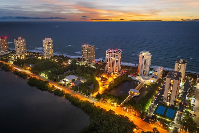 aerial view at dusk featuring a water view