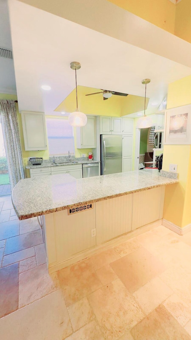 kitchen featuring hanging light fixtures, sink, kitchen peninsula, stainless steel appliances, and a breakfast bar