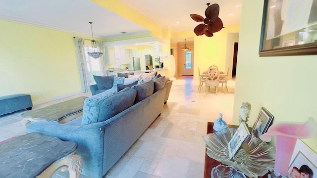 living room with ornamental molding and ceiling fan