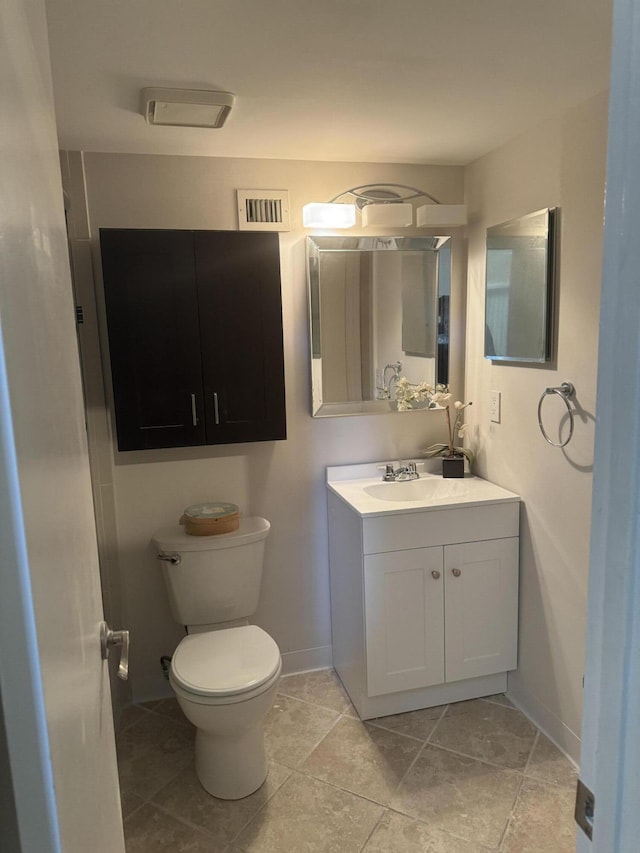 bathroom with tile patterned flooring, vanity, and toilet