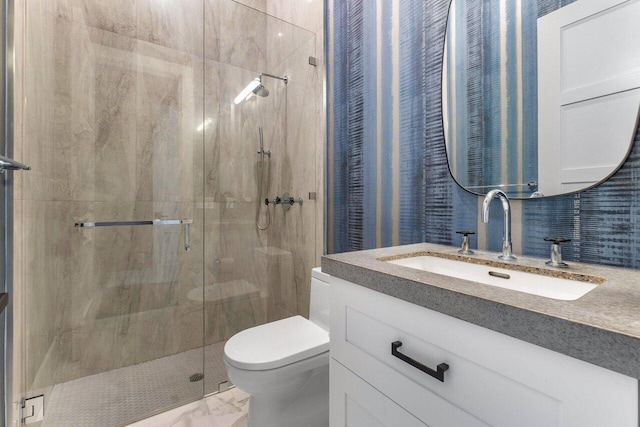 bathroom with toilet, vanity, and a shower with door