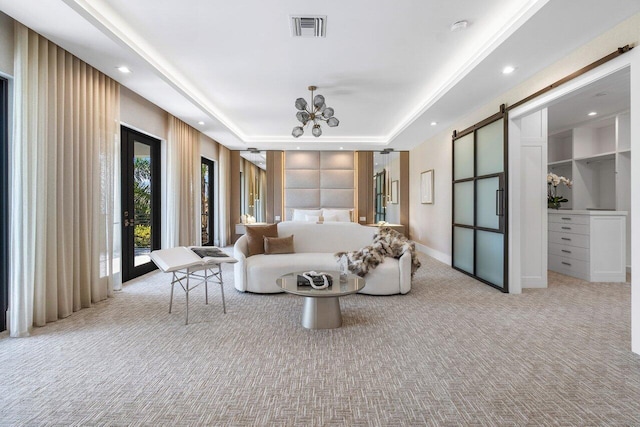 unfurnished bedroom featuring french doors, light colored carpet, a barn door, and a raised ceiling