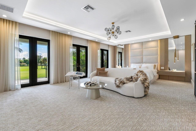 carpeted bedroom featuring a tray ceiling and french doors