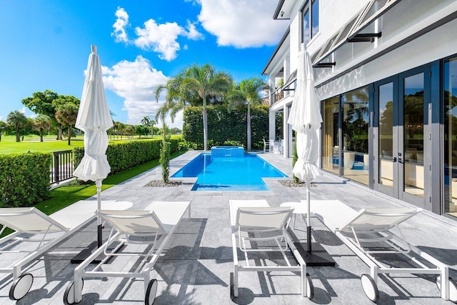 view of swimming pool with french doors and a patio area