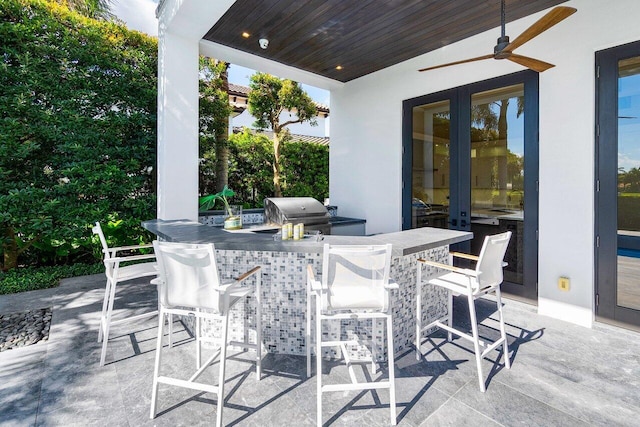 view of patio featuring a bar, area for grilling, french doors, and ceiling fan