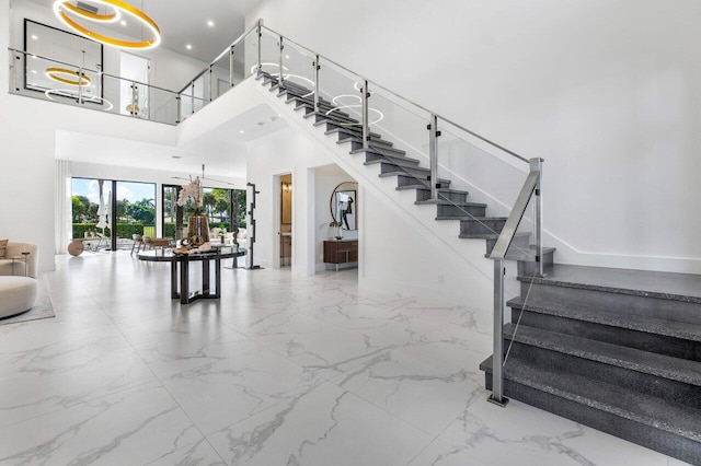 staircase featuring a high ceiling and a chandelier