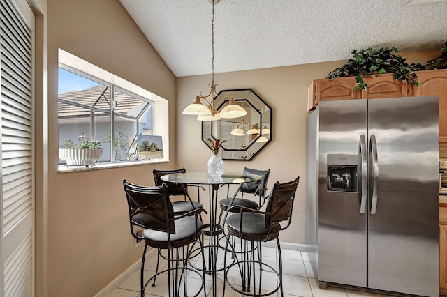 tiled dining room featuring lofted ceiling, a textured ceiling, and a chandelier