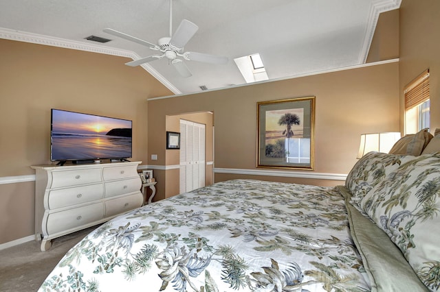 carpeted bedroom featuring ornamental molding, ceiling fan, and lofted ceiling with skylight