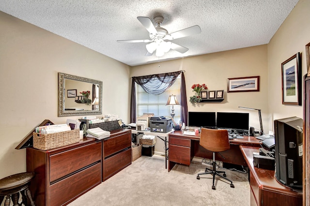 carpeted home office with ceiling fan and a textured ceiling