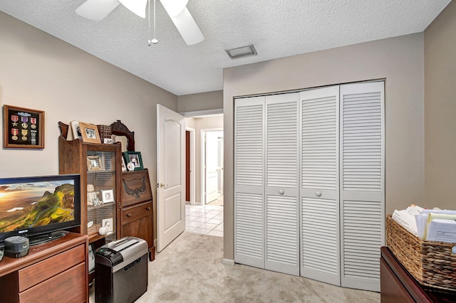 interior space with a closet, ceiling fan, and a textured ceiling