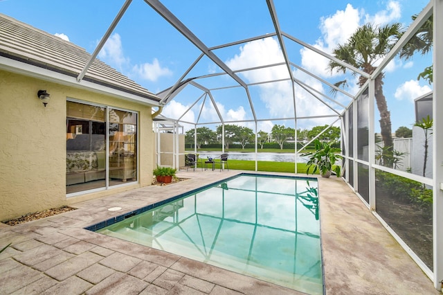 view of swimming pool with a water view, glass enclosure, and a patio