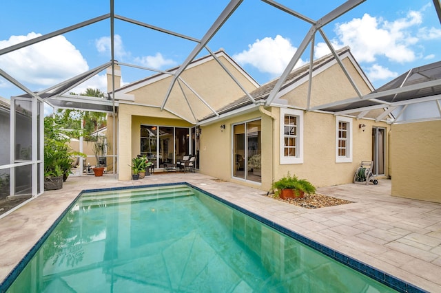 view of pool featuring glass enclosure and a patio area