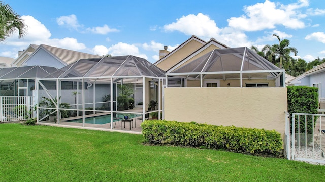 back of house with a lawn, a fenced in pool, a patio area, and glass enclosure