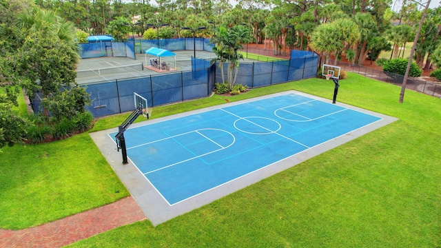 view of basketball court with a yard