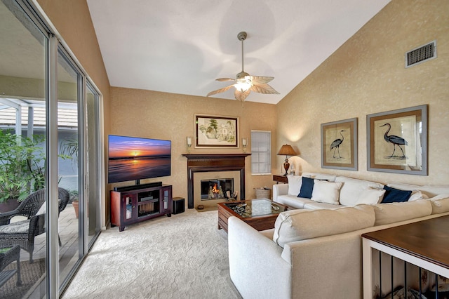 living room with ceiling fan, light colored carpet, and vaulted ceiling