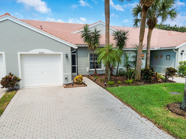 single story home featuring a front lawn and a garage