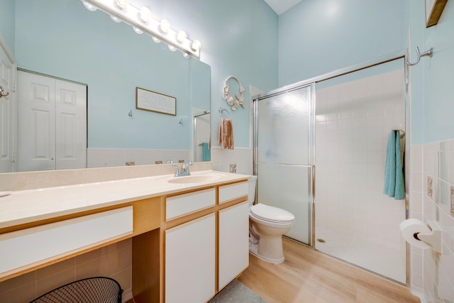 bathroom with vanity, hardwood / wood-style floors, toilet, and a shower with door