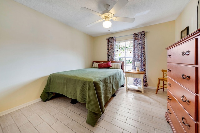 bedroom with light hardwood / wood-style floors, ceiling fan, and a textured ceiling