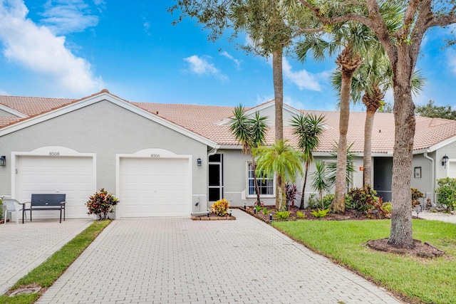 single story home featuring a garage and a front lawn