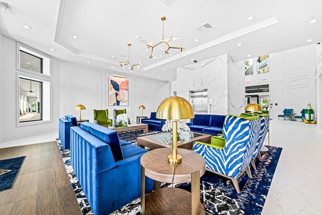 living room featuring a tray ceiling, crown molding, and a chandelier