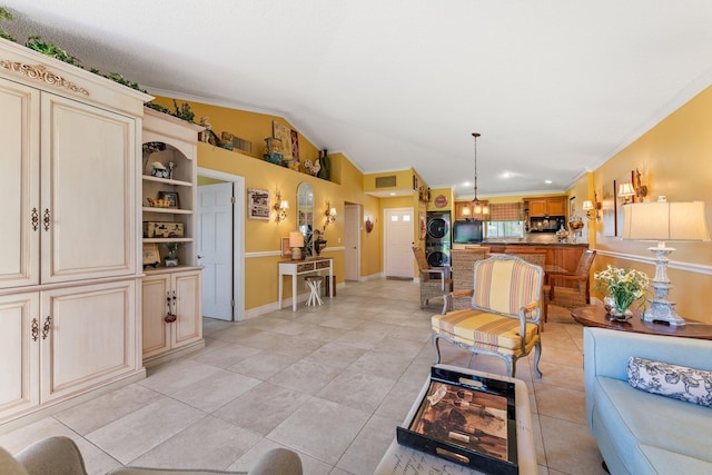 119 Club Dr, Palm Beach Gardens, FL 33418 - living area with stacked washer and dryer, lofted ceiling, ornamental molding, light tile patterned floors, and baseboards