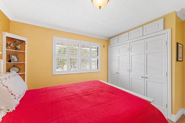 bedroom featuring a textured ceiling, a closet, and crown molding