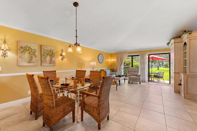 dining area with a textured ceiling, crown molding, and light tile patterned flooring