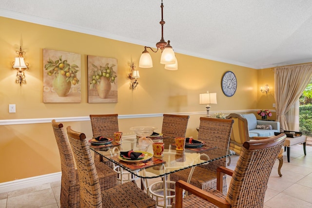 dining room featuring a textured ceiling, ornamental molding, and light tile patterned floors