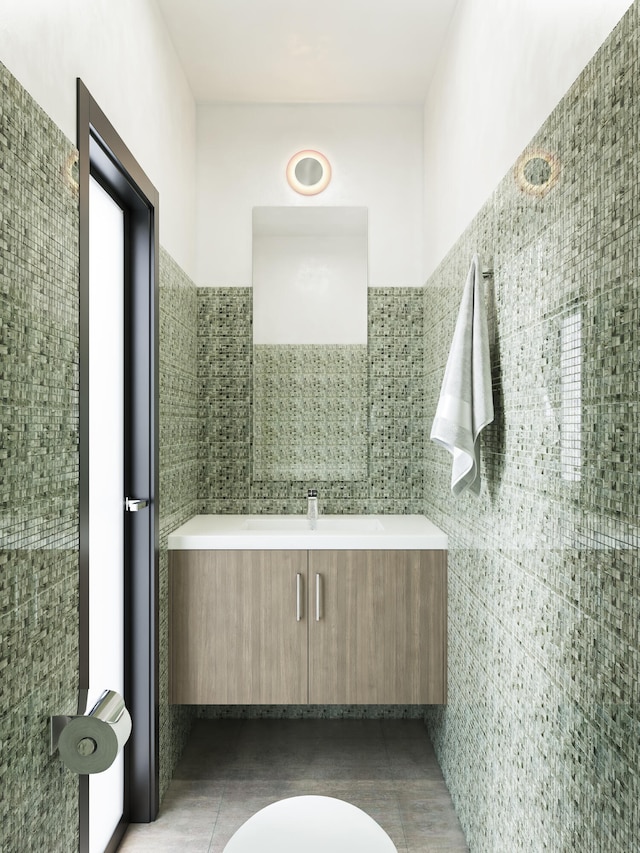 bathroom with toilet, tile patterned flooring, vanity, and tile walls