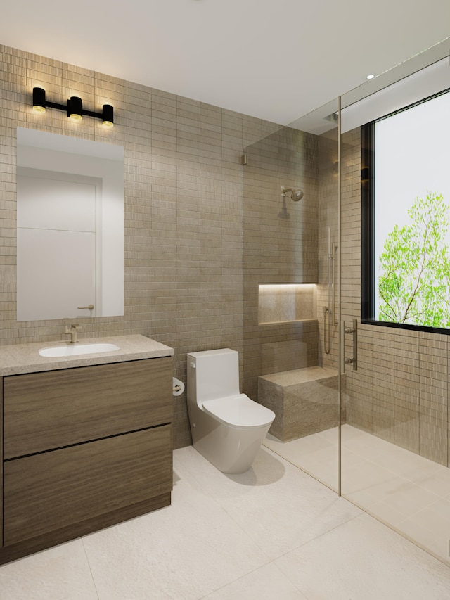 bathroom featuring tile patterned flooring, toilet, walk in shower, vanity, and tile walls