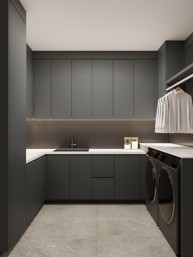 clothes washing area featuring sink, cabinets, and washer and clothes dryer