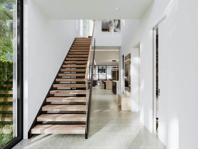 staircase with a high ceiling and plenty of natural light