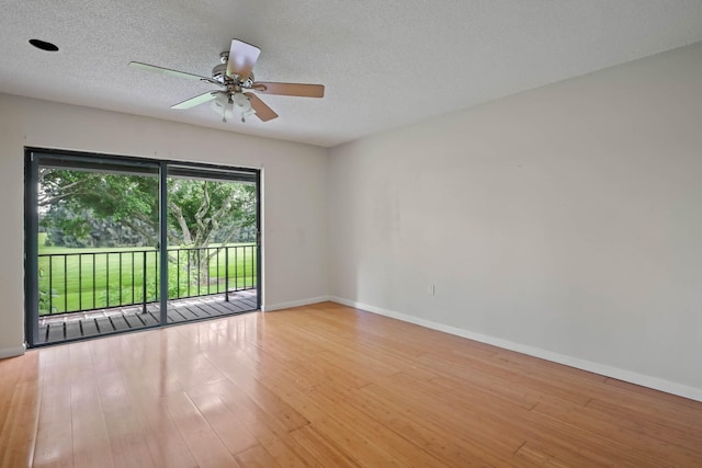 empty room with a textured ceiling, light hardwood / wood-style floors, and ceiling fan