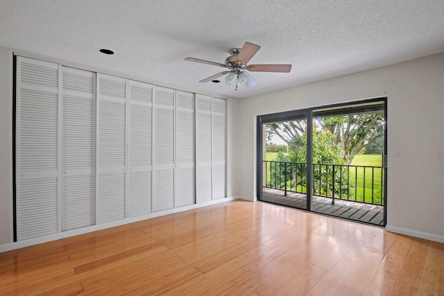 spare room with light wood-type flooring, a textured ceiling, and ceiling fan