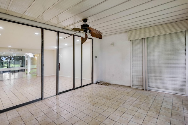 tiled empty room with a wall of windows and ceiling fan