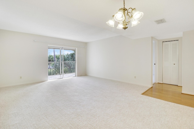 unfurnished room with light carpet and a chandelier