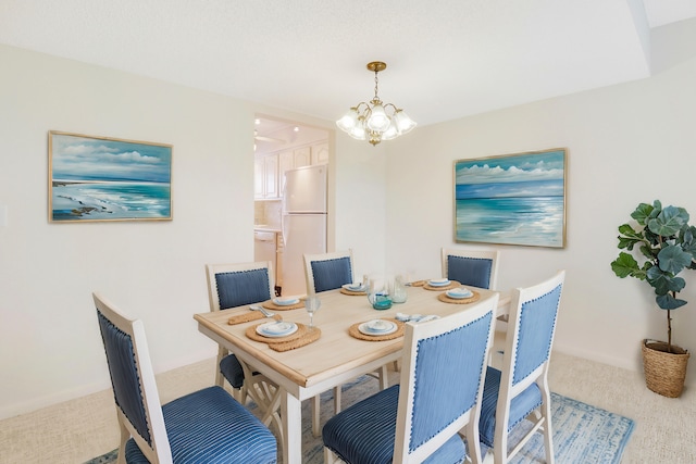 carpeted dining area with a chandelier