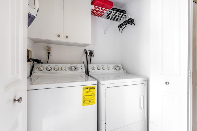 clothes washing area with cabinets and washing machine and dryer