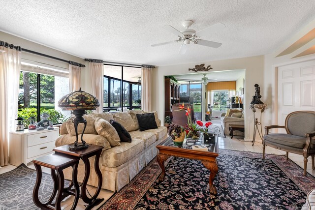 tiled living room featuring ceiling fan and a textured ceiling