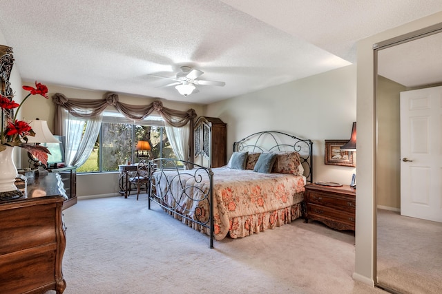 bedroom with light carpet, a textured ceiling, and ceiling fan