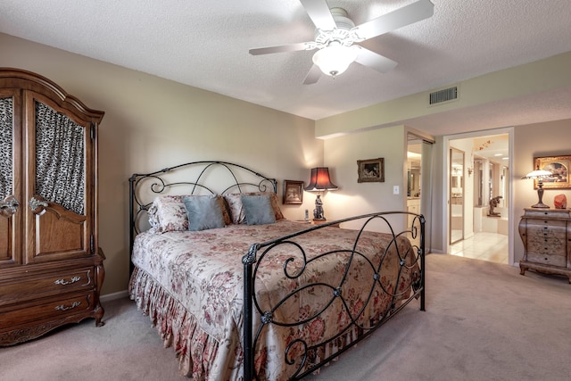 bedroom featuring connected bathroom, a textured ceiling, light colored carpet, and ceiling fan