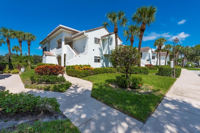 view of front of property featuring a balcony and a front lawn