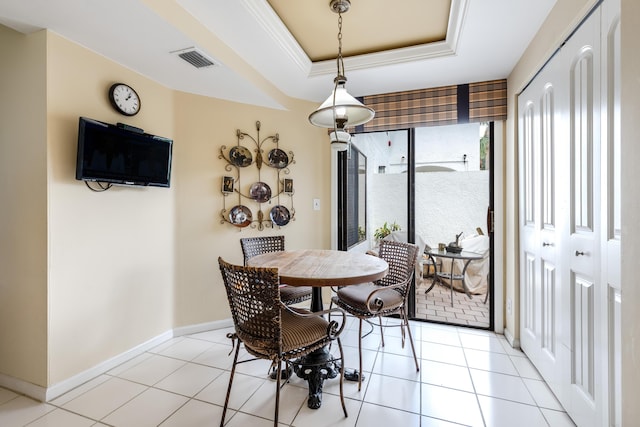 tiled dining space featuring a tray ceiling