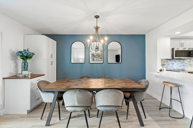 dining room featuring light wood-type flooring and a notable chandelier