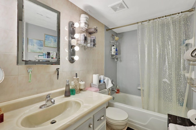 full bathroom featuring tile walls, decorative backsplash, shower / bath combo with shower curtain, vanity, and toilet