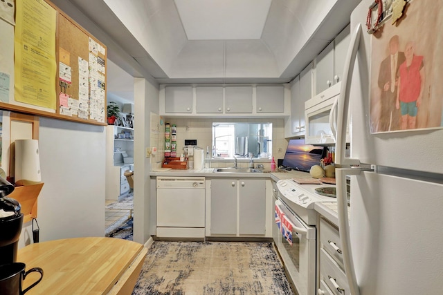 kitchen featuring decorative backsplash, white appliances, white cabinetry, and sink