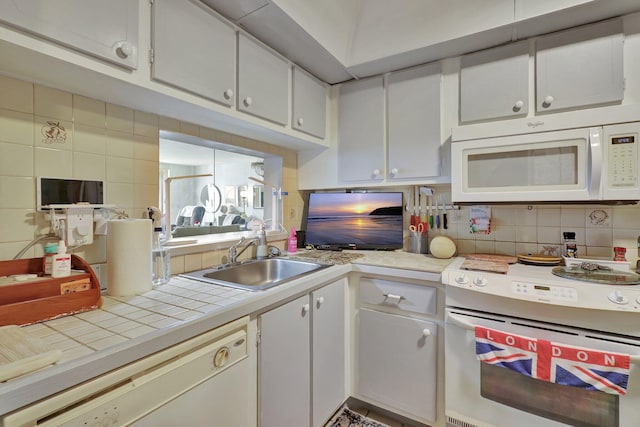 kitchen featuring white cabinetry, backsplash, white appliances, tile counters, and sink