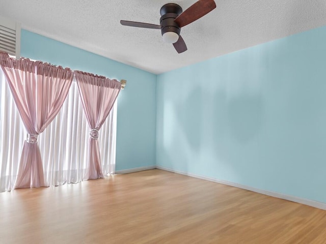 empty room featuring ceiling fan, a textured ceiling, and light hardwood / wood-style flooring