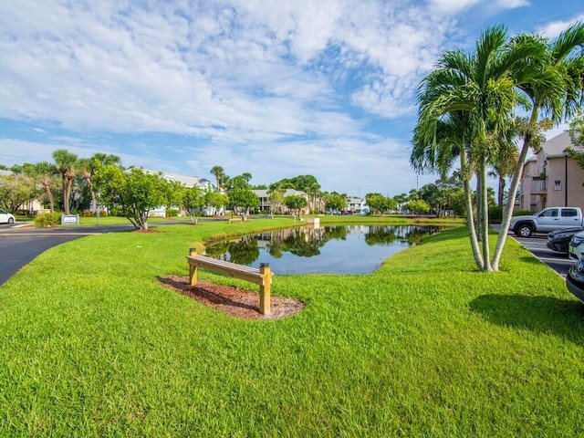 view of property's community featuring a lawn and a water view