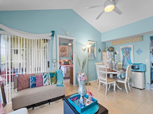 living room with ceiling fan, light tile patterned flooring, and lofted ceiling